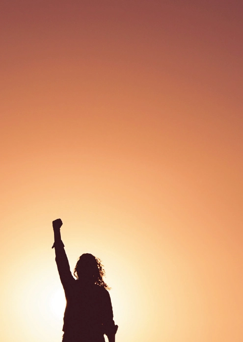 Coachee, welche nach erfolgreichem Coaching einen Arm nach oben streckt