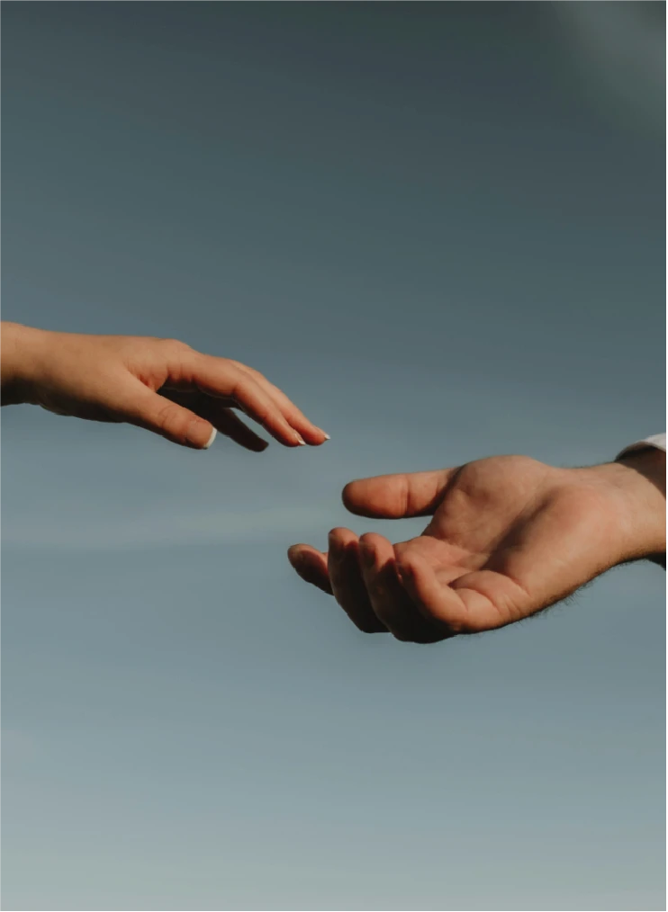 Hände von Coach und Coachee, welche sich versuchen zu erreichen